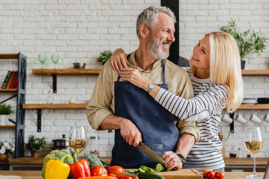 Couple laughing while cooking together at home