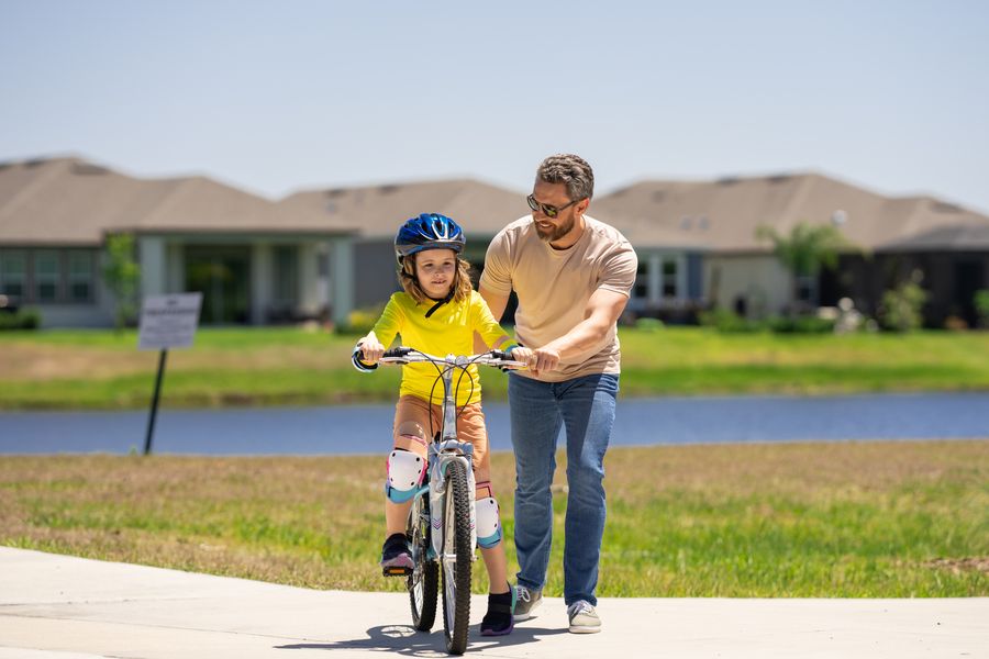 Father teaching his daughter to ride a bike in their neighborhood