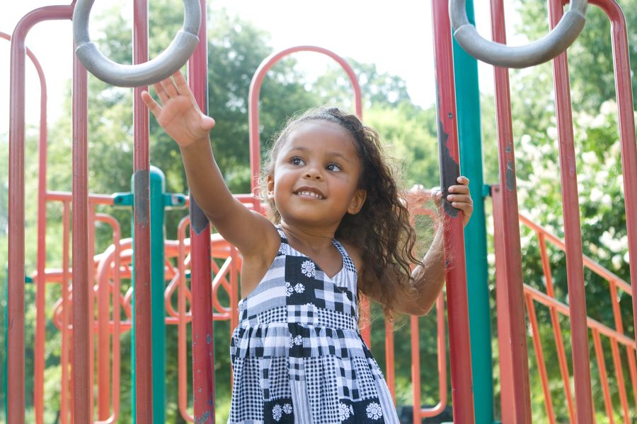 Young girl smiling on a neighborhood playground